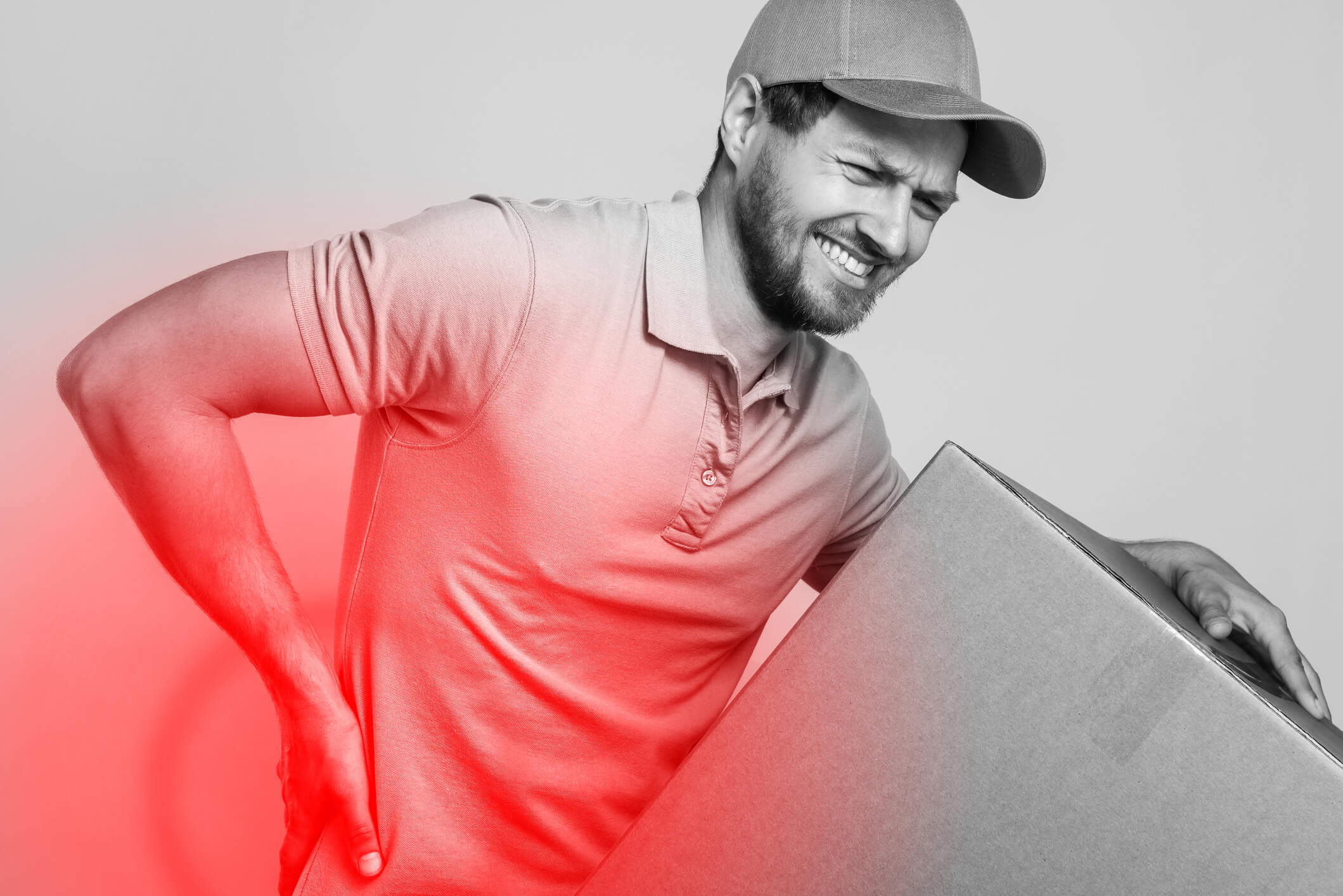 Delivery man suffering from a back pain while carrying heavy cardboard box
